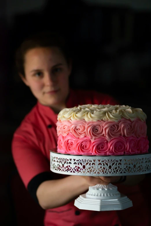 a person holding a cake decorated with roses