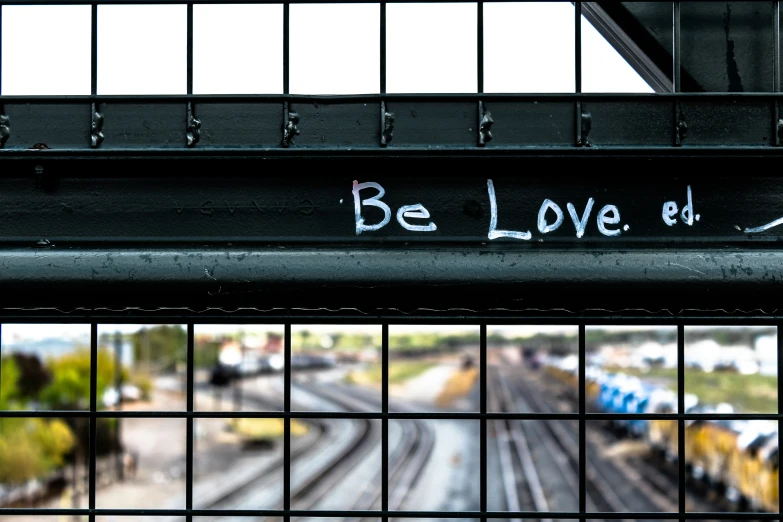 a metal fence with graffiti written on it