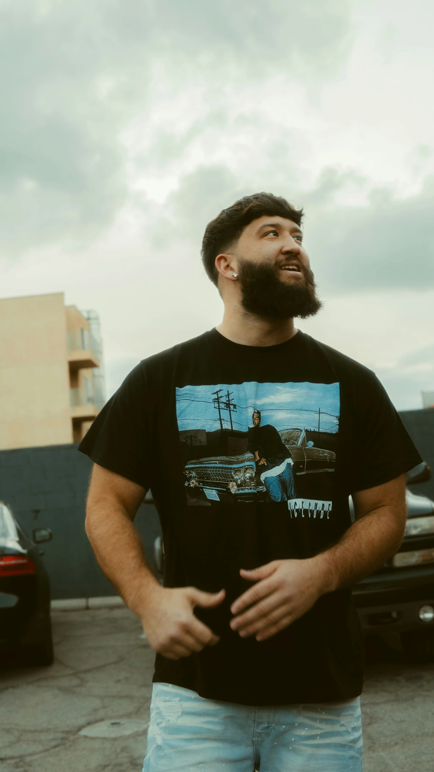 a man with beard and glasses standing on concrete