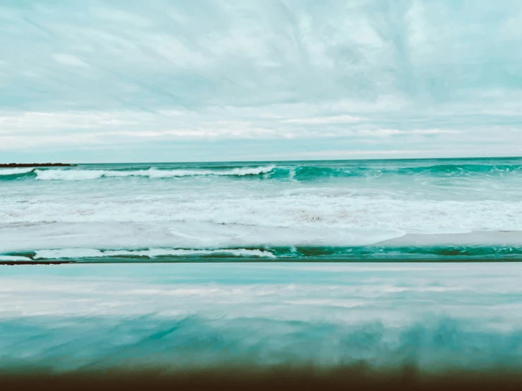 ocean waves rolling in to shore from beach