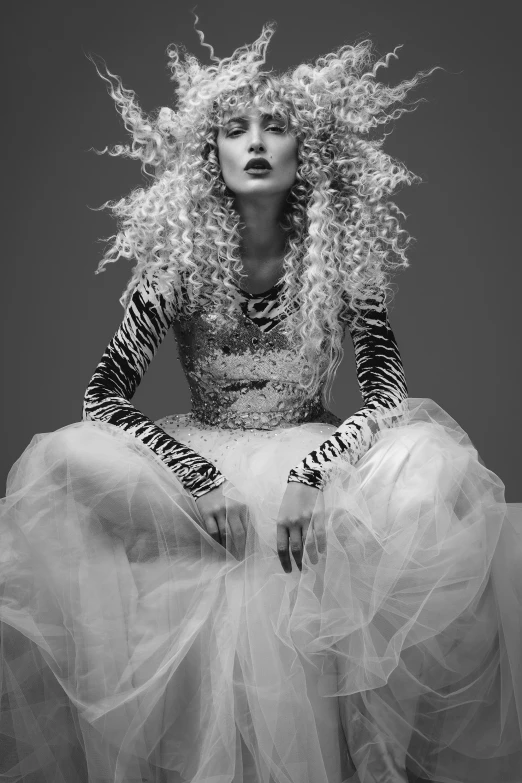 a woman is sitting with long white hair