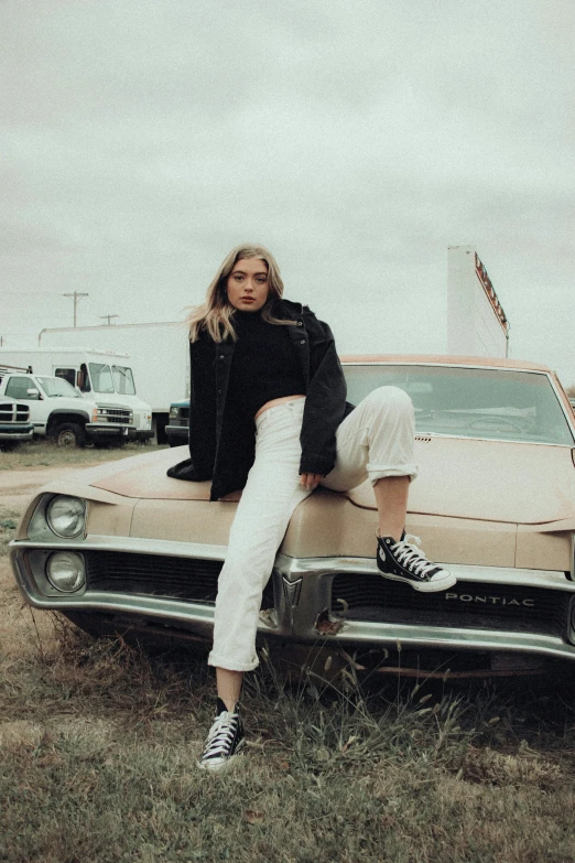 woman sitting on top of antique car with american flag