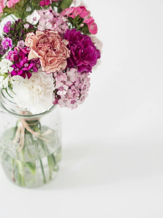 many different flowers arranged in a jar