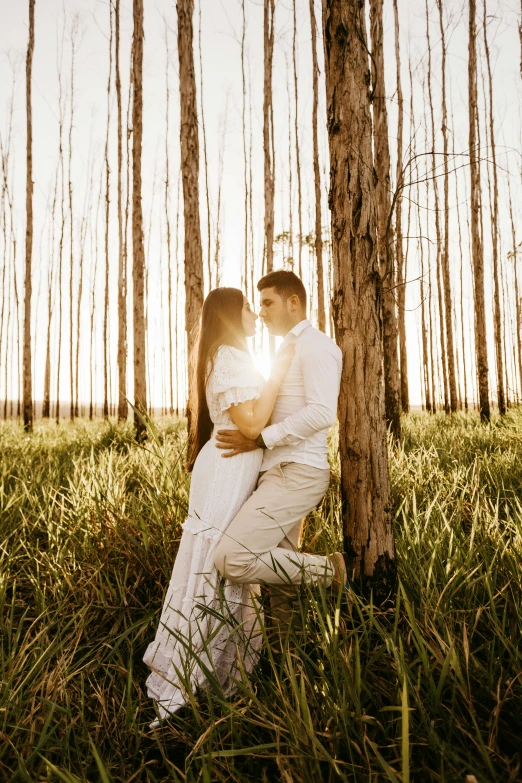 an image of a couple emcing while sitting under a tree