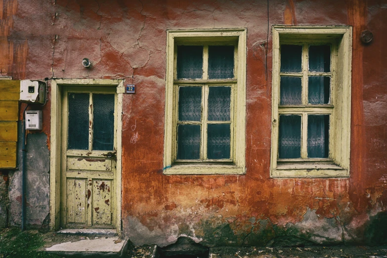 two window frames sit on an old dilapidated house