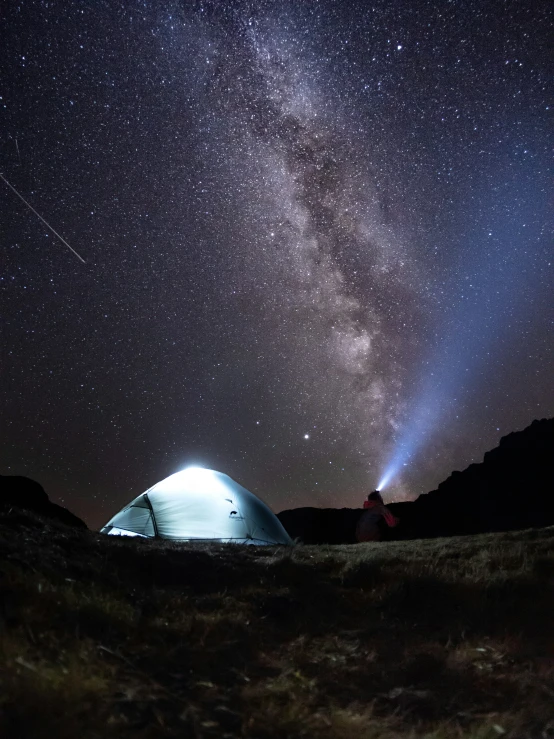 an illuminated tent under stars filled sky