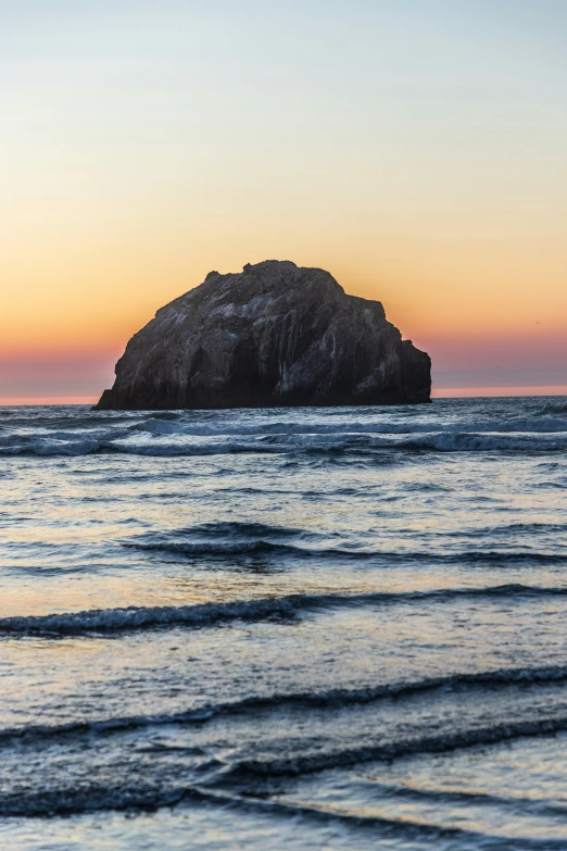 a large rock in the middle of water