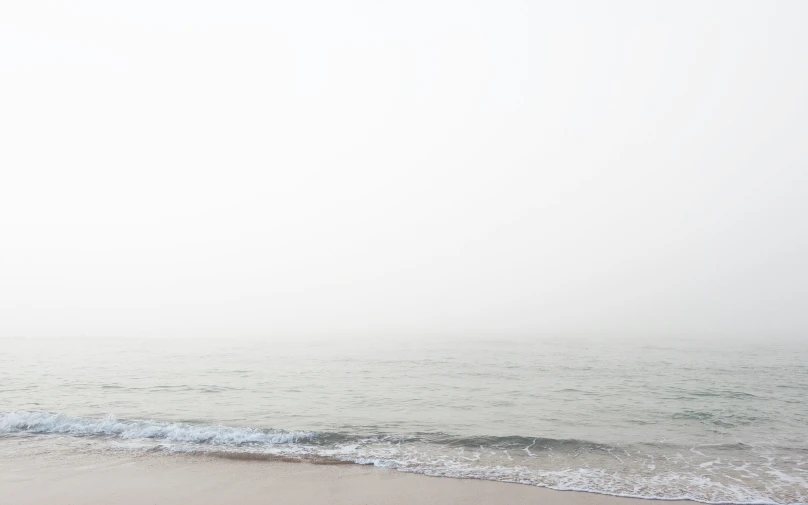 a boat is sitting in the water off the beach