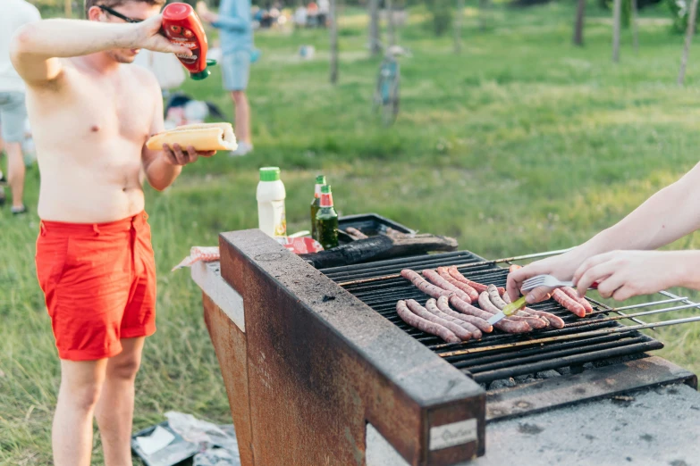 people grilling  dogs on a bbq grill outside