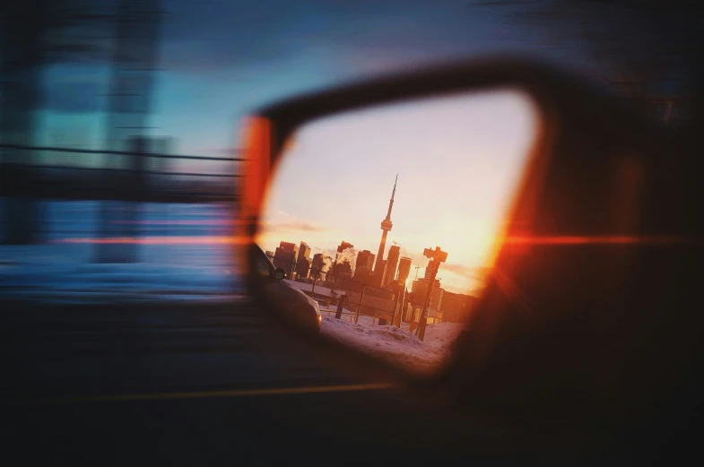 the back mirror on a car with some buildings reflected in it