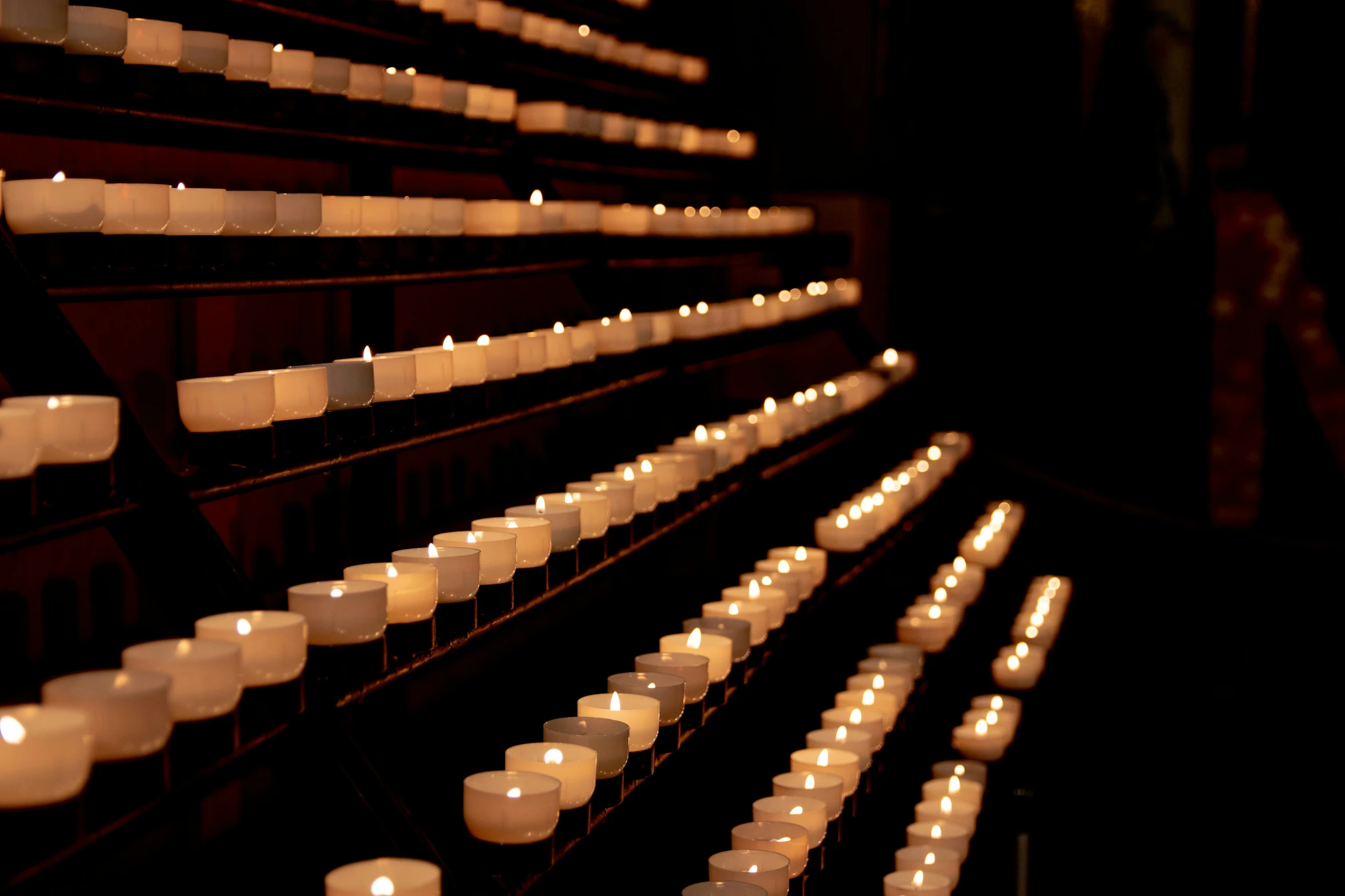 a wall of small, white candles in rows