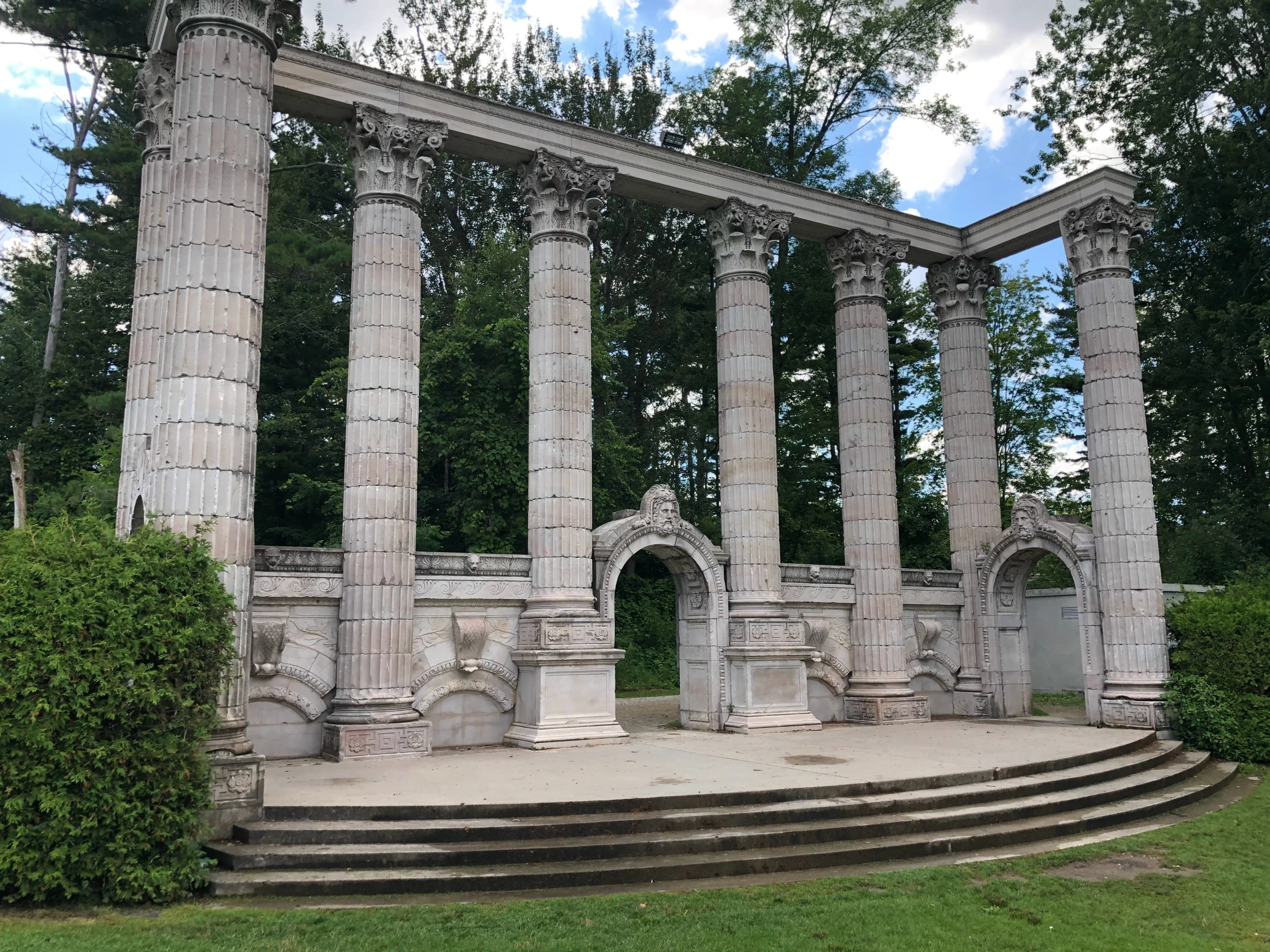 a stone structure in a lush green park