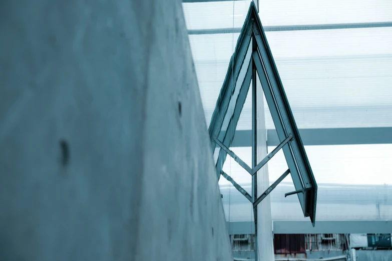 the modern metal clock is near a white building