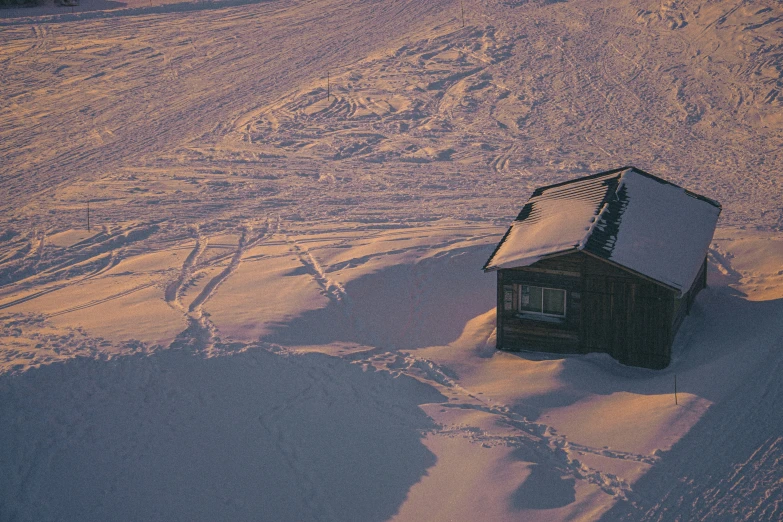 an aerial s of a single cabin in the snow