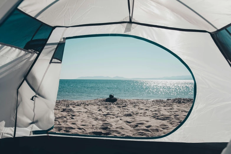 the view from inside of an outdoor tent near the ocean