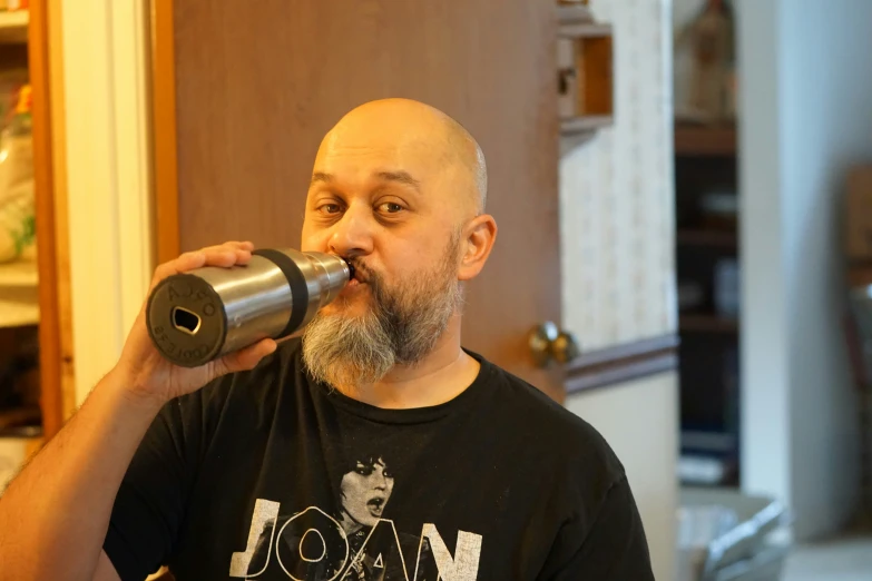 a man with an odd face drinking from a tube