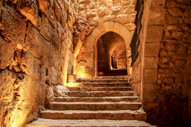 stone stairs through a tunnel and in between stone walls