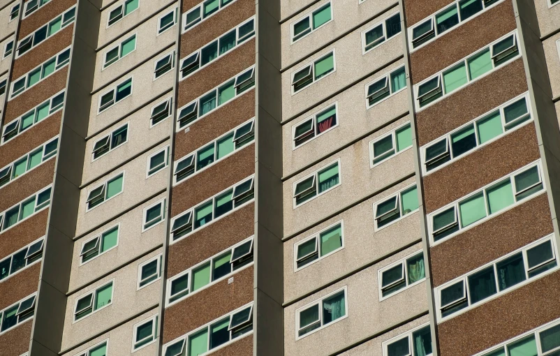 a big tall brown building sitting under an overpass