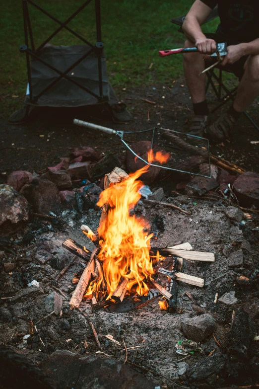 a campfire is being lit with sticks