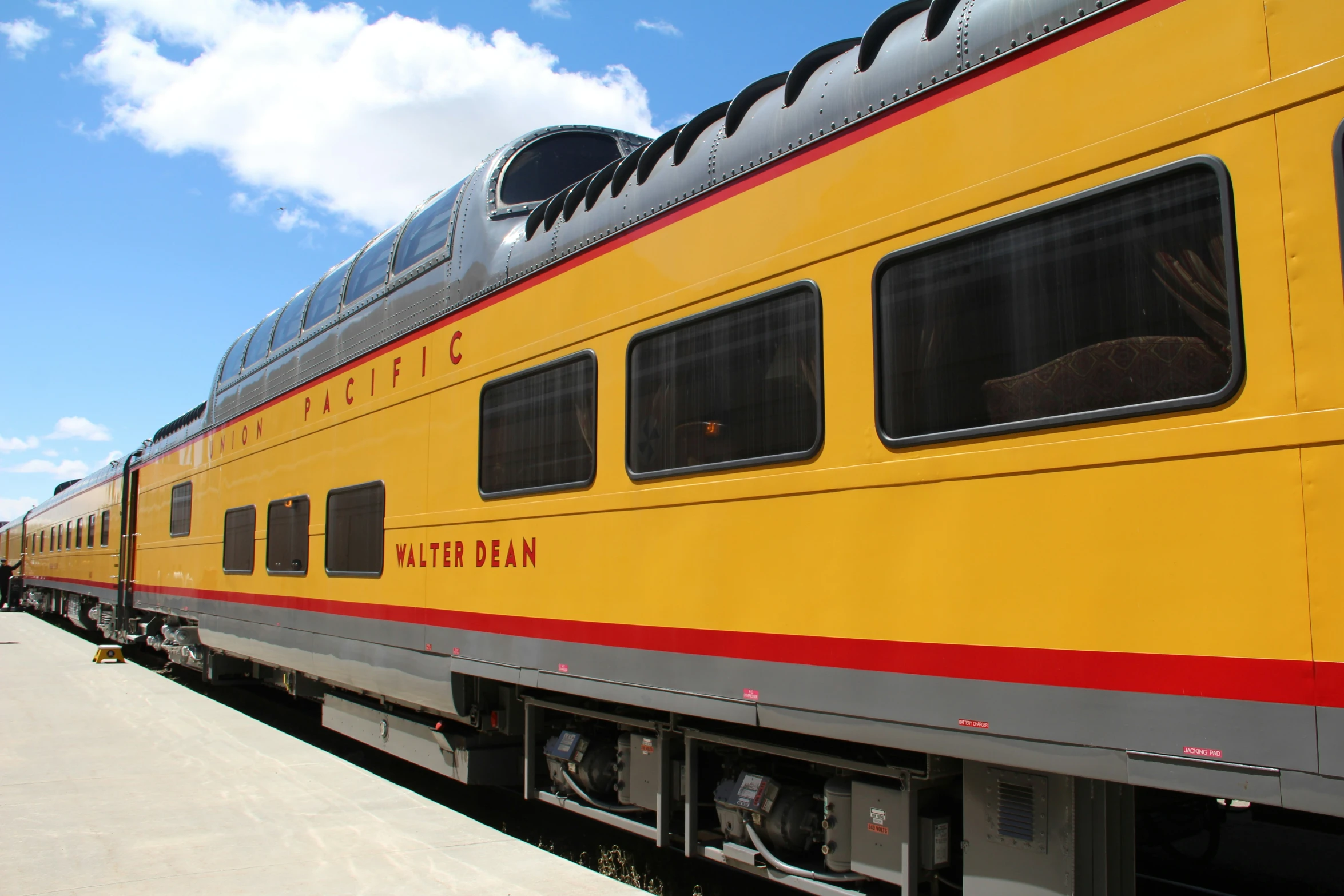 a train with people walking near by on the track