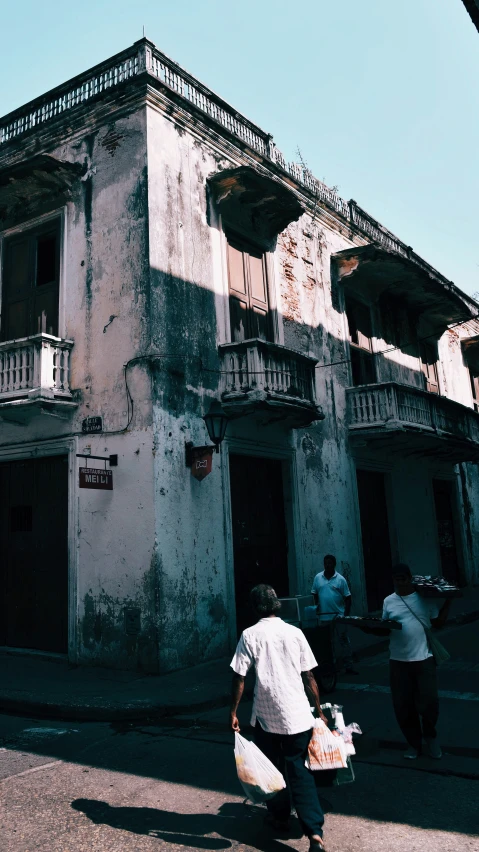 an old building with people walking on the street