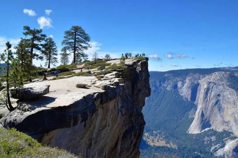 two people on the edge of a cliff overlooking a valley and mountain