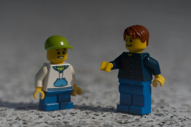 two lego figures one male and the other female with a green hat