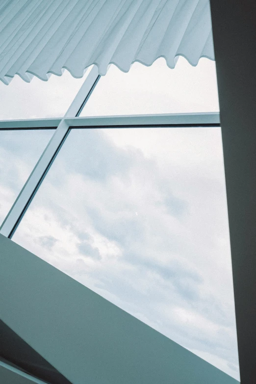 looking through a window at a building on a cloudy day