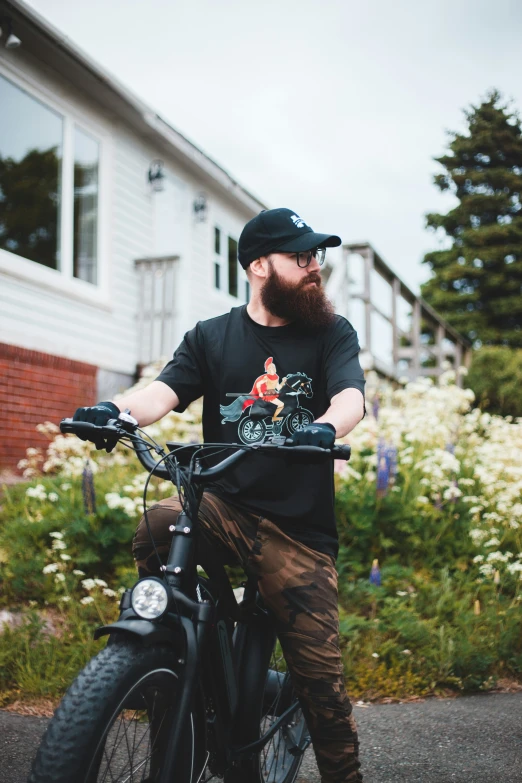 a bearded man in black shirt riding on bicycle