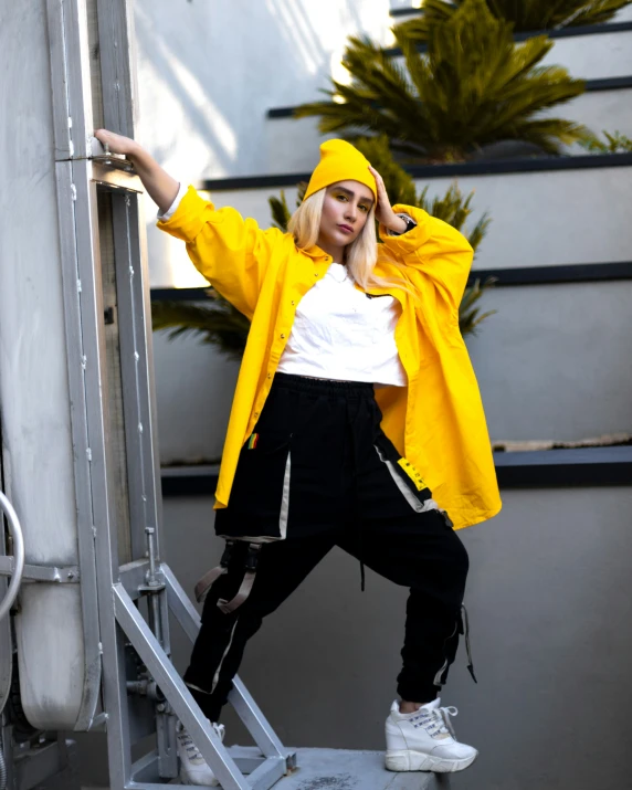 a woman wearing a yellow raincoat is posing