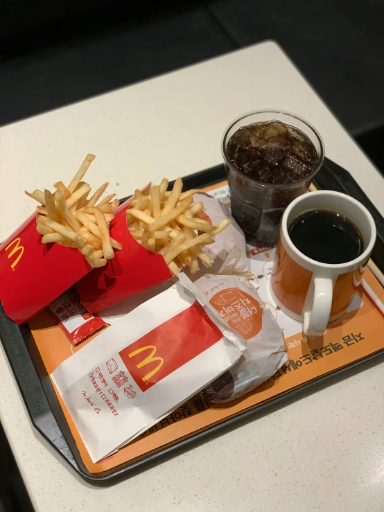 french fries are on a tray with a drink