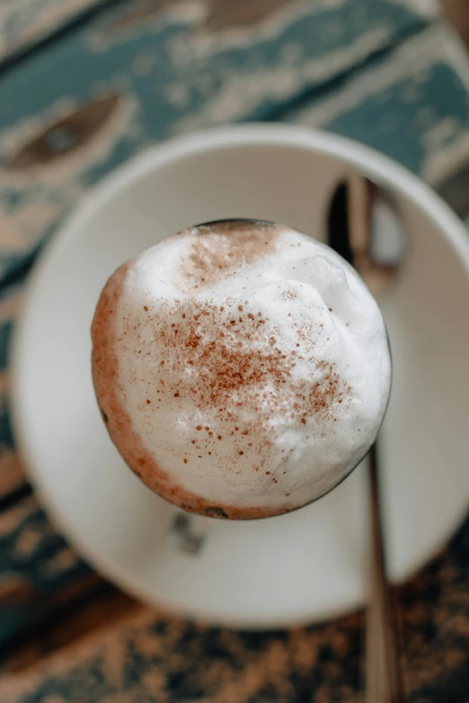 a cup of drink with cinnamon on top and a spoon