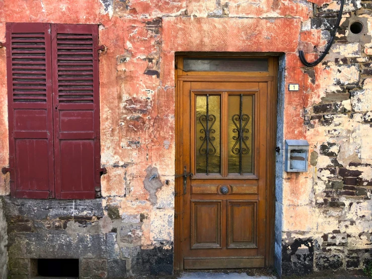 a closed and boarded up wooden door next to an old building