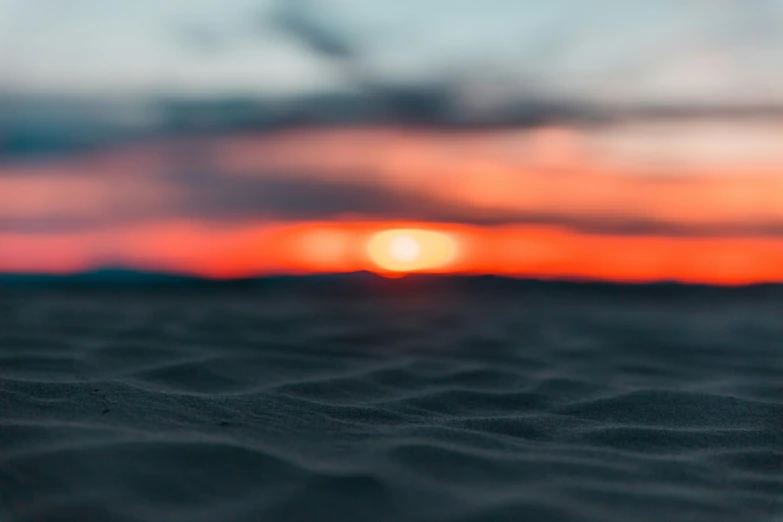 a blurry sunset with a small wave of water