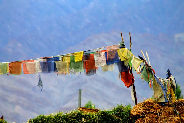 a group of multi - colored fabric hanging on a dry line in the mountains