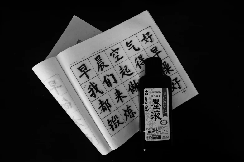 a bottle of ink and an oriental letter are displayed on a piece of paper