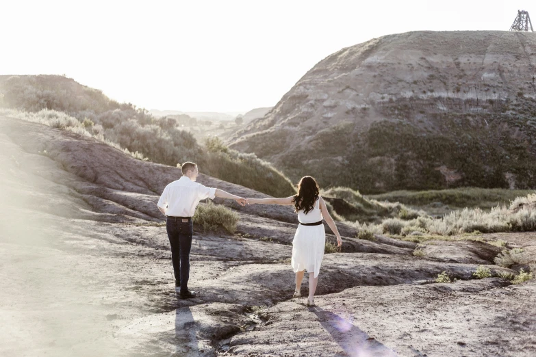 a couple walking on the side of a dirt road