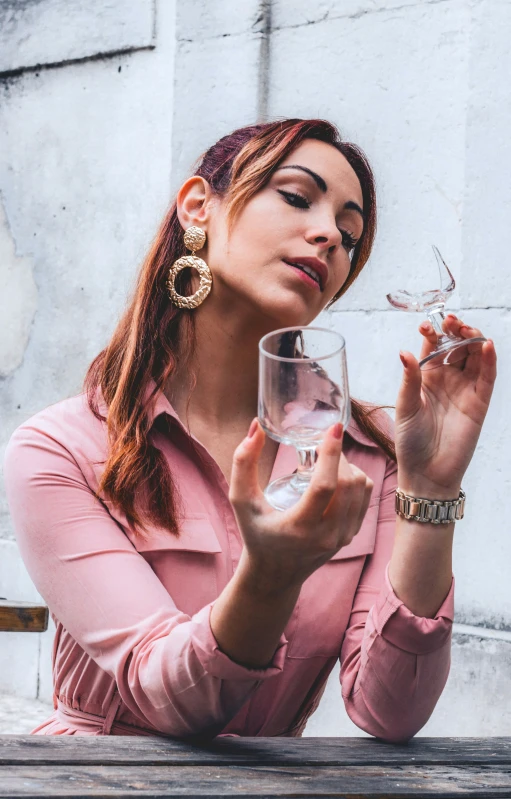 a woman holds a wine glass and holds it near her face