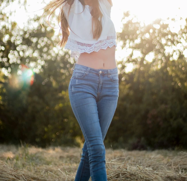 a woman wearing jeans and crop top posing for a picture