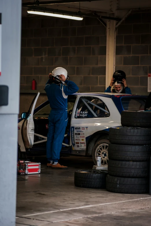 the person is getting ready to get into the race car