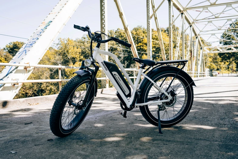 a bicycle parked next to a bridge near trees