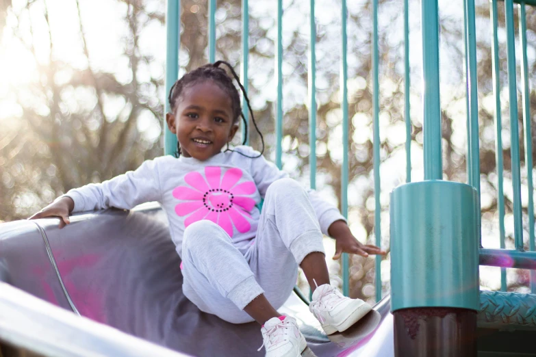 a girl on the slide on the playground