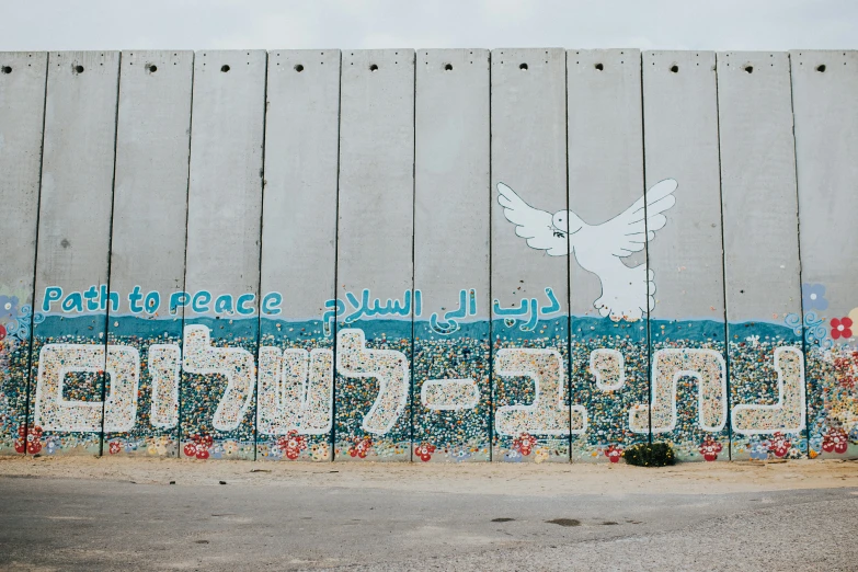 a large wall with writing on it and a white dove in the middle