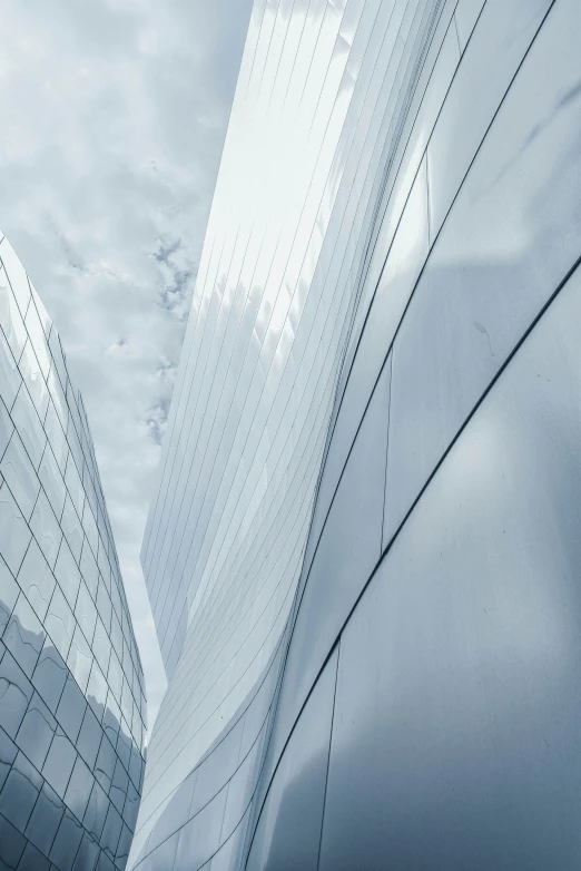 two tall buildings against a cloudy blue sky