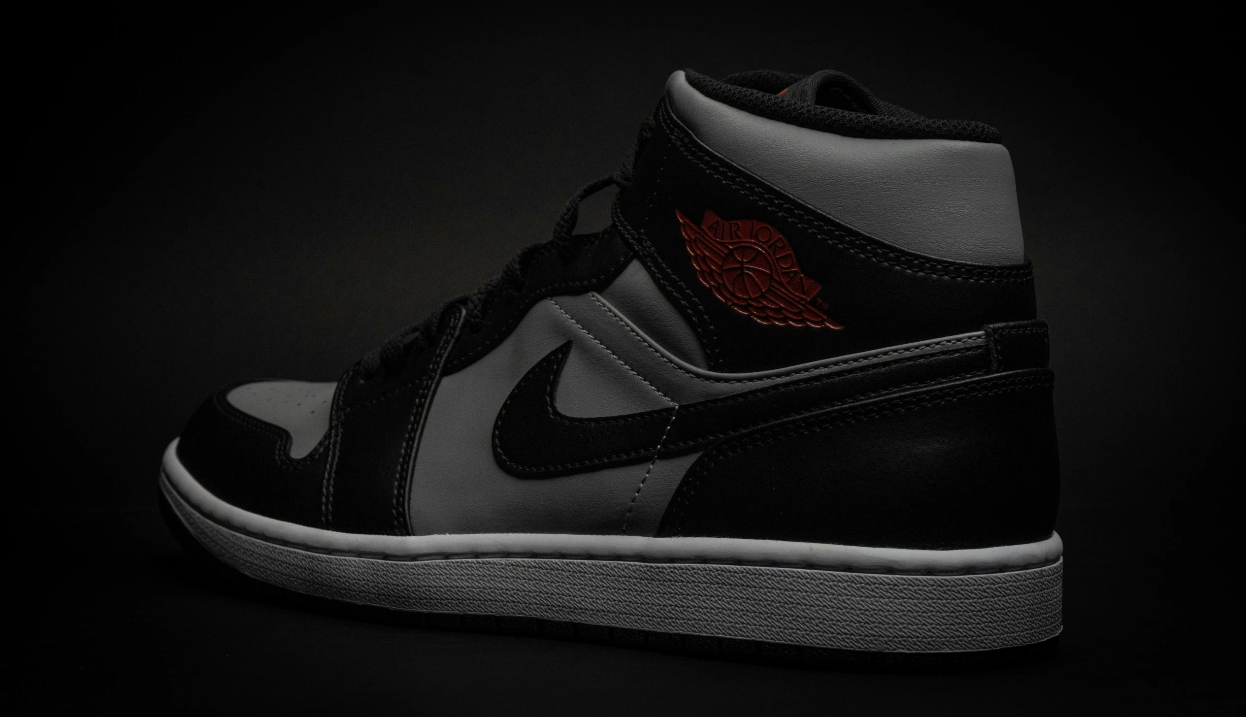 a pair of sneakers with a red - on - black bottom