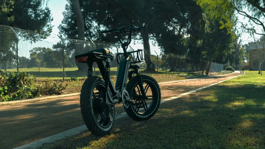 a bike is  to a fence by a road