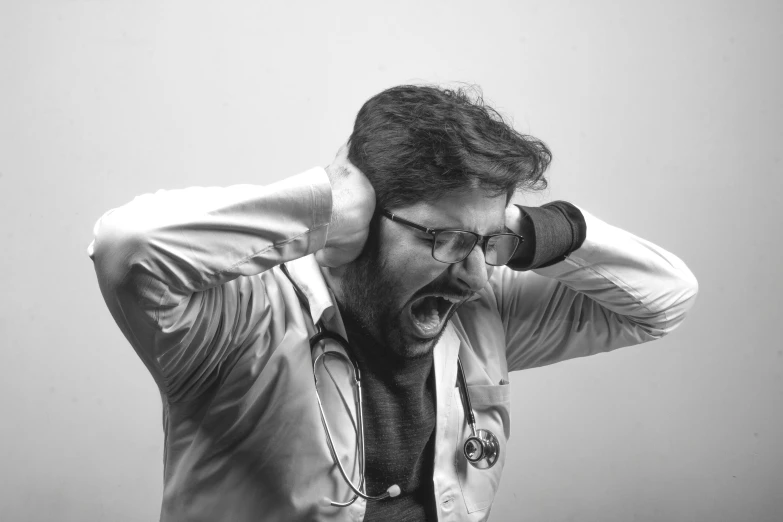 man covering his ears while talking on the phone