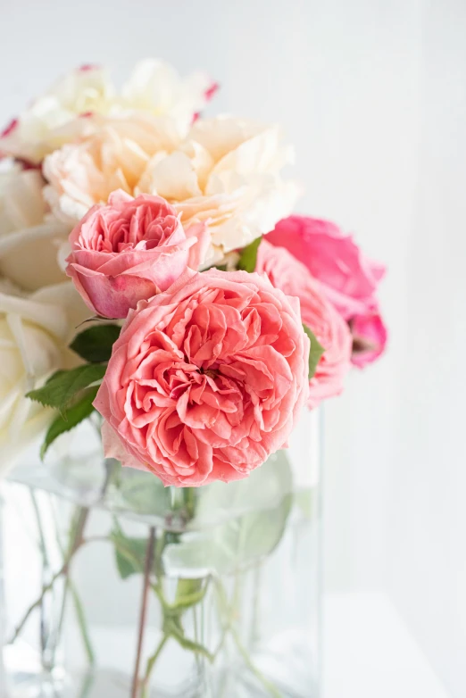 a clear vase with pink and yellow flowers