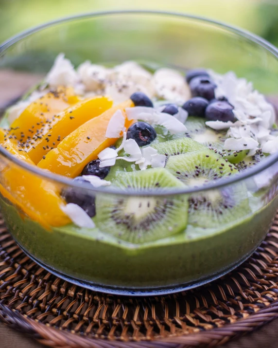 a bowl of ding made up of kiwi, blueberries and orange slices