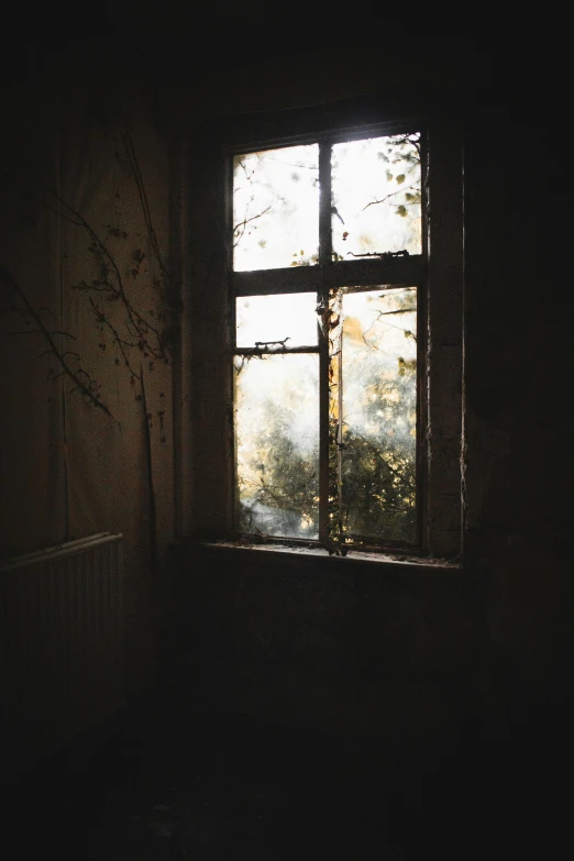 the sunlight shines through the window pane in a dark room